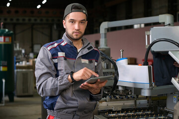 Portrait of a young worker of an assembly line at a factory for the production