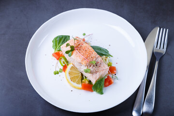 Trout (salmon) with vegetables, lemon and microgreens, cooked by the confit method. Traditional French dish. Step by step. Close-up.