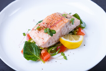 Trout (salmon) with vegetables, lemon and microgreens, cooked by the confit method. Traditional French dish. Step by step. Close-up.