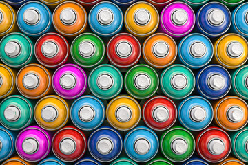 Top view of colorful graffity spray paint cans or bottles of aerosol.