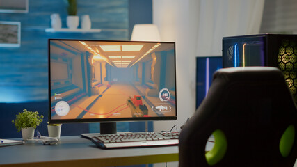 Empty cyberspace with RGB powerful personal computer with first-person shooter game on screen in...