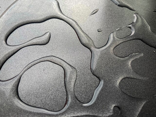 Fototapeta na wymiar Drops of water on gray non-stick metallic surface. 