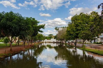 Paisagem. Foto do lago do Parque Balneário rodeado de árvores com céu azul com algumas nuvens.
