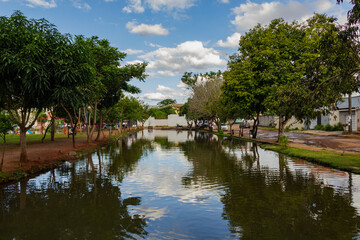 Fototapeta na wymiar Paisagem. Foto do lago do Parque Balneário rodeado de árvores com céu azul com algumas nuvens.