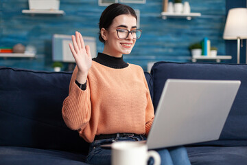 Young woman greeting her teacher during virtual videocall meeting talking about university project. Student in living room on online internet web video conference duting virtual e-learning class © DC Studio