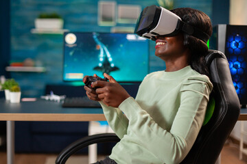 African gamer e-sports with vr sitting in chair using wireless controler. Virtual space shooter...