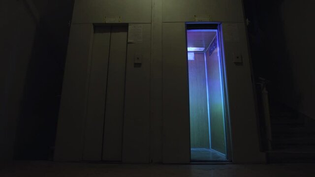 Elevator doors open and close on an empty floor with flashing disco lights inside, concept of party. Stock footage. Unusual elevators inside night club.