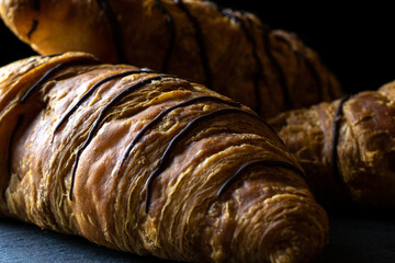 Croissant french. Fresh pastry bread or french breakfast croissants with chocolate in bakery on black stone table. Homemade croissants, best for coffee.