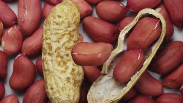 Rotating grain of peanuts against the background of other grains. Close-up. View from above.