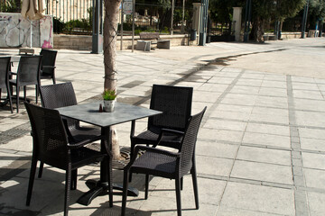 Fototapeta na wymiar Table and empty chairs at street cafe