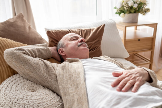 Senior Man Asleep In Bed At Home Napping After Breakfast