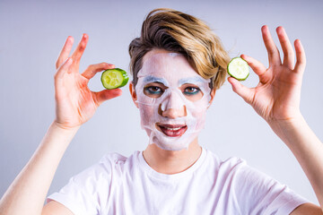 non binary portrait of asian man with luxurious blonde hair and gorgeous make-up in white wall studio background with face moisturizing mask