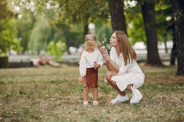 Naklejka na ściany i meble Mother with little daughter playing in a summer park