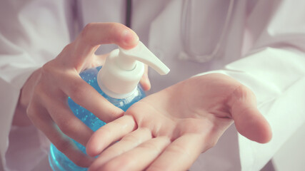 Closeup of a female doctor in a hospital waring white uniform is rubbing in palm use sanitizer alcohol gel washing hand to prevent from coronavirus disease and antibacterial for healthy living,