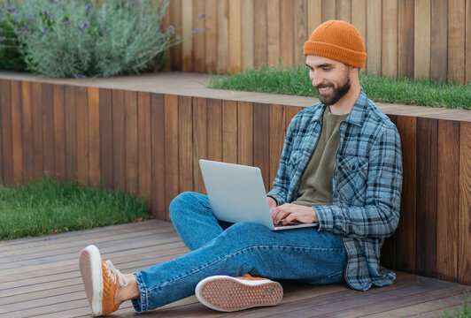 Young smiling programmer develop software , working freelance project from home. Handsome bearded man using laptop computer shopping online, watching videos. Happy student studying, distance learning 