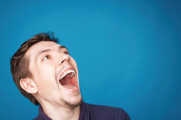 Excited white skinned man laugh open mouth widely being glad and shocked, rejoices positive news about something. Surprised man in casual clothes can`t believe his great success, good luck or skill