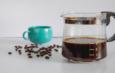 Coffee jar glass with cup and coffee maker on background.