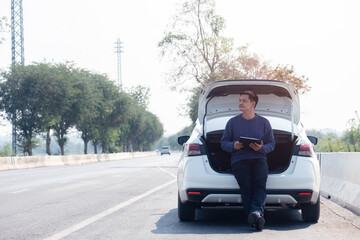 Asian traveler man  sitting on car with hightway road background