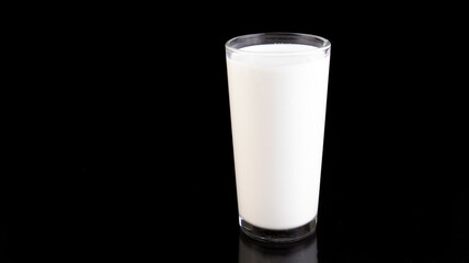 glass of fresh milk on black background, isolated