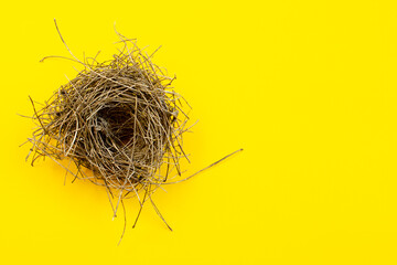 Top view of empty bird's nest on yellow background, top view, copy space. Bird nest isolated on yellow, top view. Empty bird nest on a yellow background, top view. Copy space.