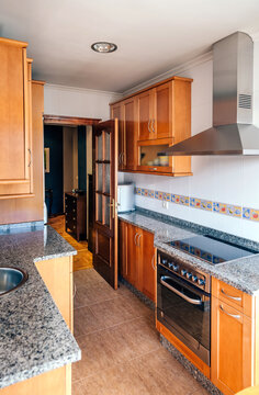 Interior of kitchen on two fronts with wooden furniture