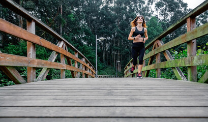 Obraz na płótnie Canvas Athlete woman running through an urban park