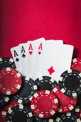 Poker game with a four of a kind or quads hand. Chips and cards on the red table