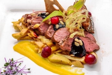 Baked meat with fried potatoes and berry sauce