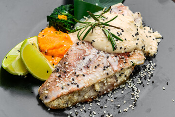 Grilled sea bass with white sauce and lemon