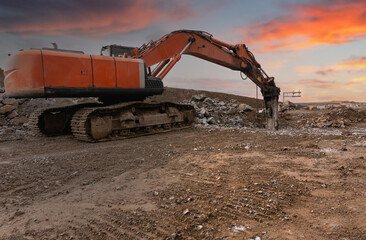 Fototapeta na wymiar Excavator with hydraulic hammer on road construction works