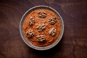 Red peppers spread with walnuts in bowl. Traditional Middle eastern muhammara dish.