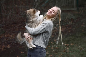 Young woman holding a puppy Finnish Lapphund dog