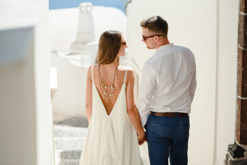 Happy couple hugging and laughing together with a view of Santorini