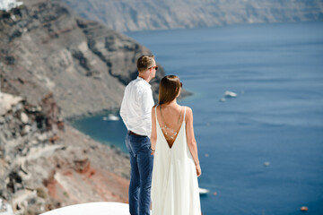 Happy couple hugging and laughing together with a view of Santorini