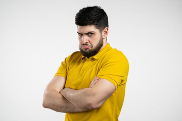 Angry offended man keeping arms crossed and staring at camera with sceptical and distrustful look, feeling mad at someone. Human facial expressions, emotions and feelings. Body language