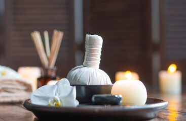 Fototapeta na wymiar Spa background. Towel, candles, flowers, aroma sticks, massaging stones and herbal balls. Massage, oriental therapy, wellbeing and meditation.