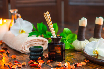 Spa background. Towel, candles, flowers, aroma sticks, massaging stones and herbal balls. Massage, oriental therapy, wellbeing and meditation.