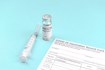 Vaccination health control background, hospital table with record card, medical syringe and vaccine vial