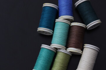 colorful thread spools on a black background