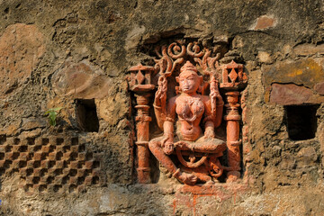 A statue of a deity embedded in a wall on the island of Mandhata located in the Narmada River in Omkareshwar, Madhya Pradesh, India.