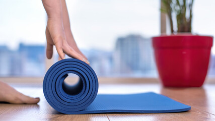Woman unwinding a yoga mat
