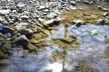 pebble river stones in the water. Pebbles under water. The view from the top. Nautical background. Green lake water