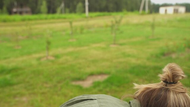 A blond-haired mother and her son higging and laughing in summer garden
