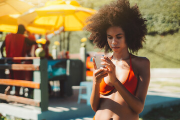 Portrait of a young ravishing African-American female with fluffy afro hair and in a swimsuit...