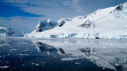 Fototapeta na wymiar Snow covered Mountains and Icebergs in the Antarctic Peninsula on Antarctica.