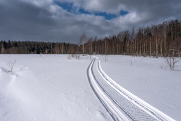Obraz premium snowmobile track on a snow-covered sunny field
