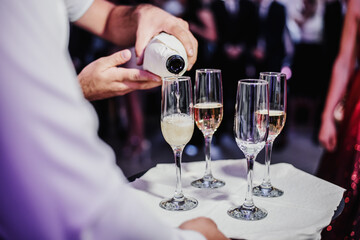 waiter pours champagne into the glasses