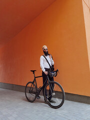 Fototapeta premium A young stylish hipster posing next to his bicycle.