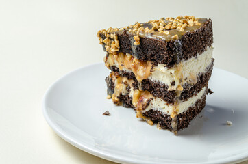 chocolate biscuit cake with nuts. with condensed milk on a white platter High quality photo