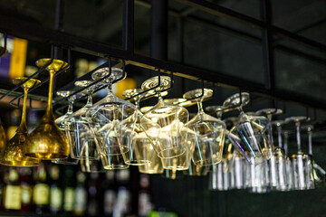 Rows of empty wine glasses on the showcase in the restaurant or bar. Table setting, close up. Glasses for alcohol.